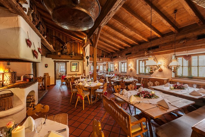s'Pfandl interior made of wood with traditional stove, coffee set, antlers and pictures