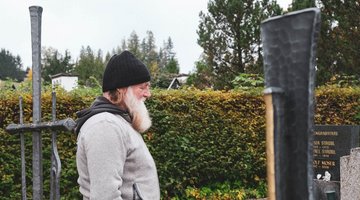 Der Friedhofswärter vor einem Grab