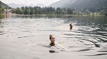 Paar schwimmt im Schwarzsee 