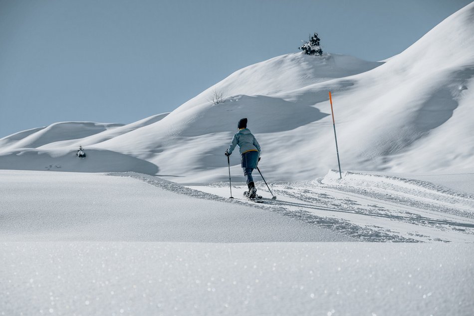 Eine Dame geht Skifahren am Kitzbüheler Horn im weißen Schnee 