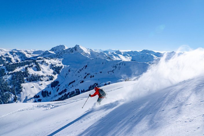 Skifahrer fährt durch Tiefschnee 