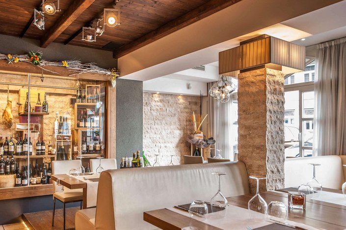 Hostaria Kitzbühel Italienisches Restaurant mit mediterraner Ausstattung, Steinen und Weinflaschen