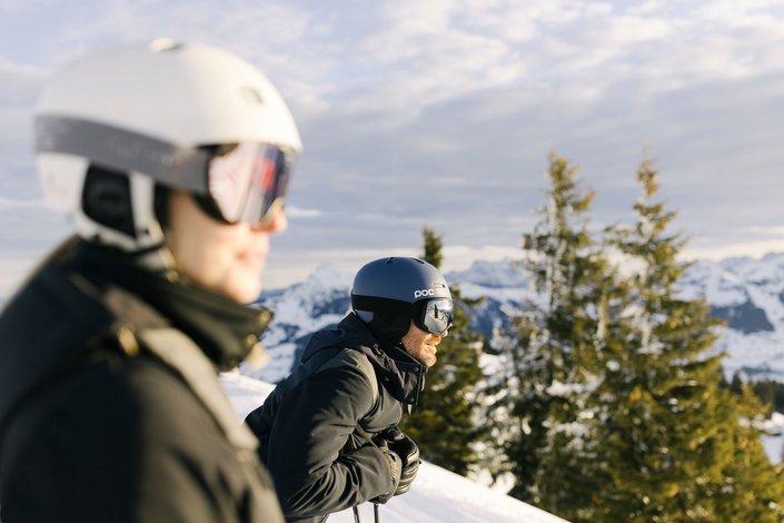 Mann und Frau genießen den Ausblick beim Skifahren