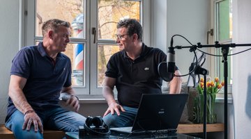 Zwei Männer sitzen am Fenster
