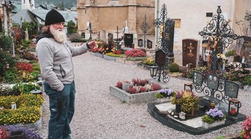 Der Friedhofswärter vor einem Grab