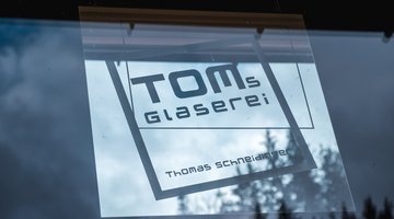Fensteraufkleber mit "Tom's Glaserei"