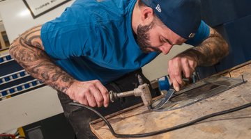 Ein Mann beim Arbeiten am Glas in einer Glaserei