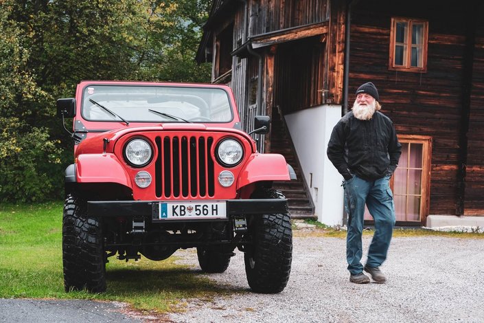 Der Friedhofswerter neben seinem roten Jeep