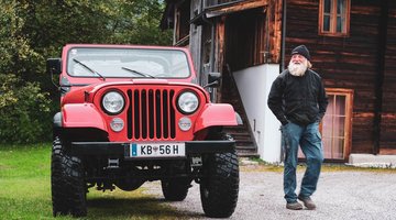 Der Friedhofswerter neben seinem roten Jeep