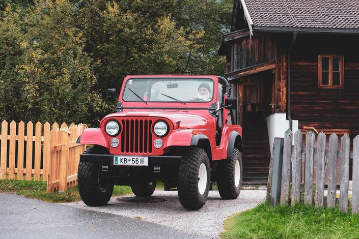 Der Friedhofswärter in seinem roten Jeep von Vorn