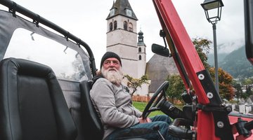 Der Friedhofswärter in seinem roten Jeep von der Seite